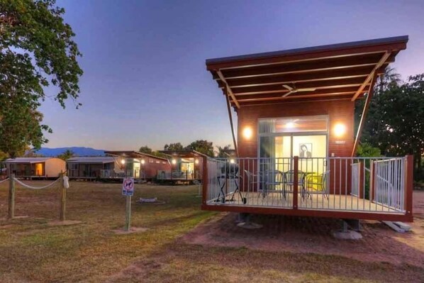 A small, single-story building with a covered porch and a fenced outdoor seating area.