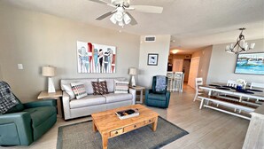 A modern living room with a sofa, coffee table, and a dining area with a table and chairs.