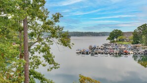 Un port esportiu amb vaixells amarrats, envoltat d'arbres i un llac tranquil.