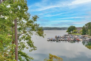 Un port de plaisance où sont amarrés des bateaux, entouré d’arbres et bordé d’un lac paisible.