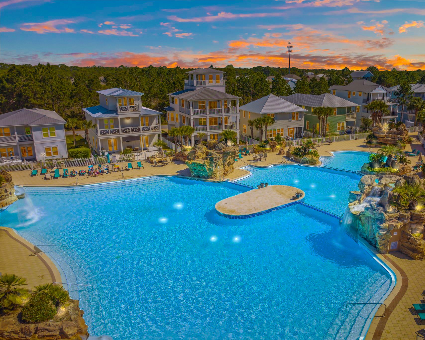 A resort with multiple swimming pools, a beach area, and a variety of buildings.