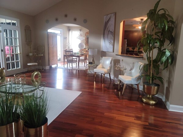 Relax in this elegantly furnished living area with a dining table, sofa, and armchairs.