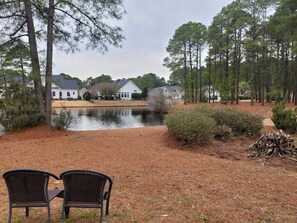 Relax in a serene natural setting surrounded by a tranquil pond and lush greenery.