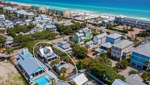 Ett bostadsområde vid kusten med hus, en strand och en pool.