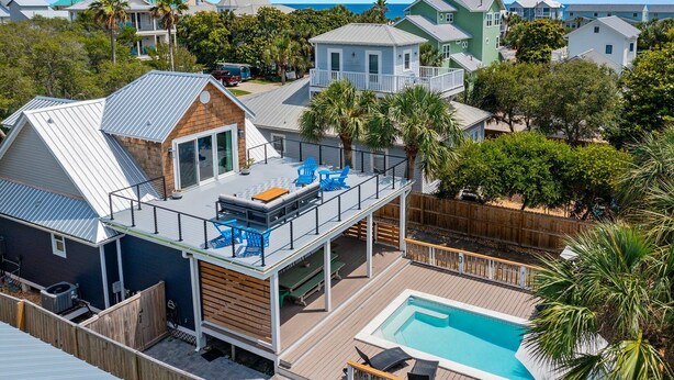 En bostadsfastighet med en takterrass, en swimmingpool och utsikt över havet.