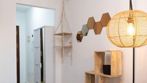 Ein Schlafzimmer mit einem Bett, einem Holzregal, einer Pendelleuchte und einem Kleiderschrank.