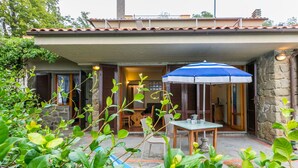 A covered outdoor patio with a table and chairs, surrounded by greenery. - Beautiful apartment for 4 guests with WIFI, pool, terrace, pets allowed and panoramic view (Lamporecchio)