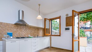 A modern kitchen with white cabinets, a gas stove, and a coffee maker. - Lovely apartment for 4 guests with pool, WIFI, balcony, pets allowed and panoramic view (Lamporecchio)