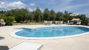 A swimming pool with lounge chairs and umbrellas, surrounded by trees and a clear sky. - Beautiful private villa for 11 guests with A/C, pool, WIFI, TV, patio and pets allowed (Sperlonga)
