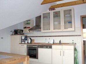 A kitchen with white cabinets, a microwave, a toaster, a coffee maker, and a dishwasher.