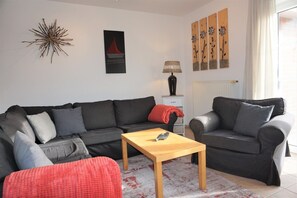 A living room with a sofa, a coffee table, and a lamp.