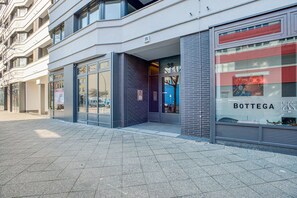Bottega storefront with large glass windows and doors, offering a clear view of the interior.