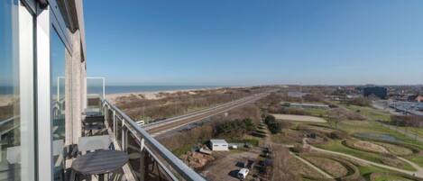 A balcony with a view of a highway and surrounding landscape.