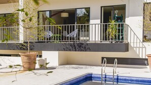 A modern outdoor pool area with a metal deck, a small pool, and potted plants. - Justo Sierra SmartLife (Guadalajara)