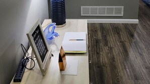 Habitación con escritorio, espejo, lámpara y detalles decorativos en la pared, incluyendo un pavo real y motivos florales.
