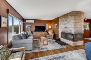 Relax in this inviting living room with a comfortable sofa, flat-screen TV, and brick fireplace.