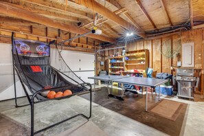Enjoy recreational activities in this basement space featuring a basketball court, ping pong table, and grill.