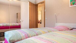 Une chambre à coucher avec un lit, une armoire, une porte et un miroir.