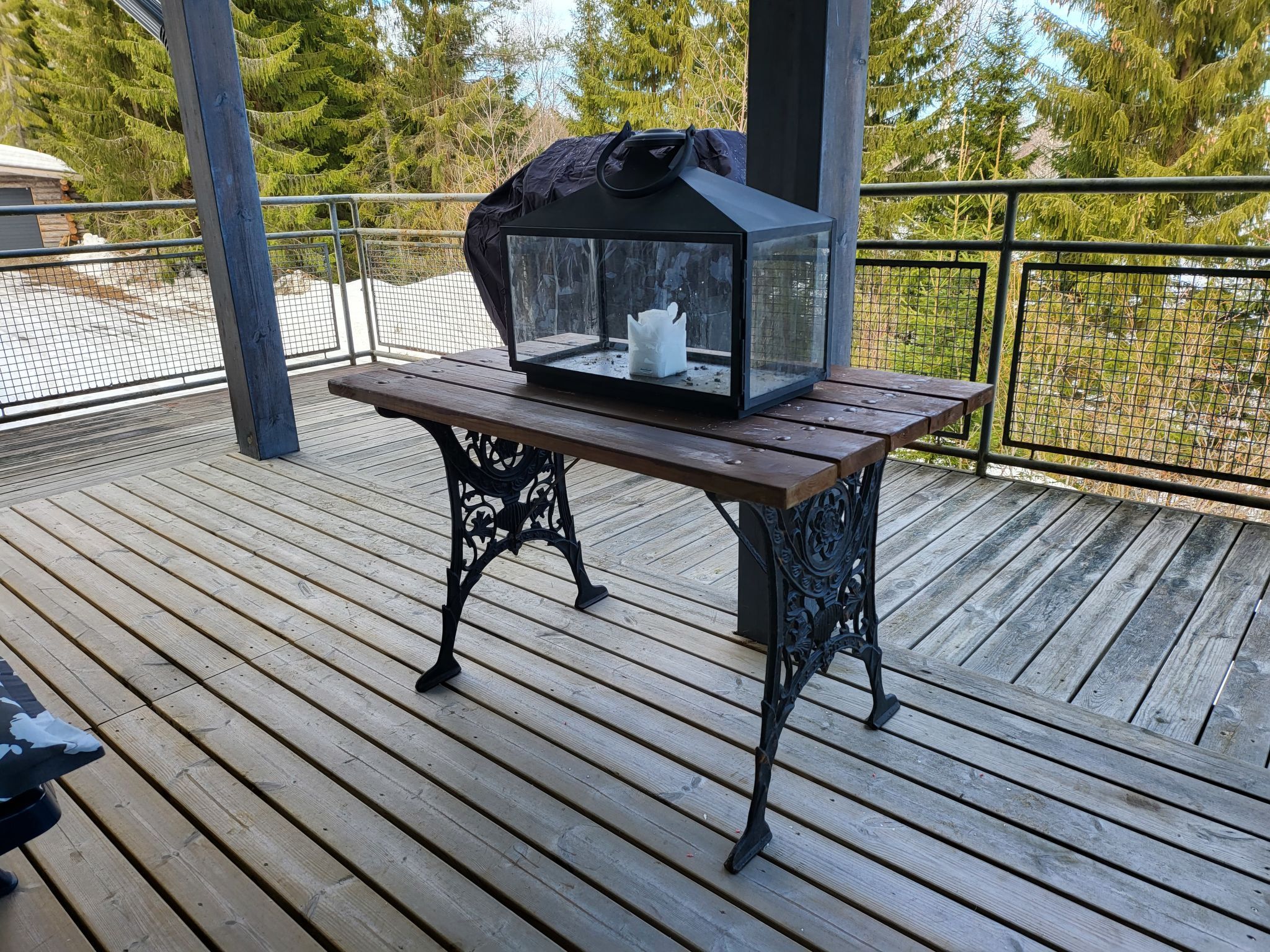 Eine Holzterrasse mit Tisch und Glasveranda.