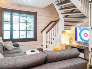 A cozy living room with a sofa, a small table, and a staircase leading to another level.
