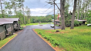 A rural road leading to a row of cabins with a speed limit sign of 5. - Riverview Cottages # 1 (Lake Luzerne)