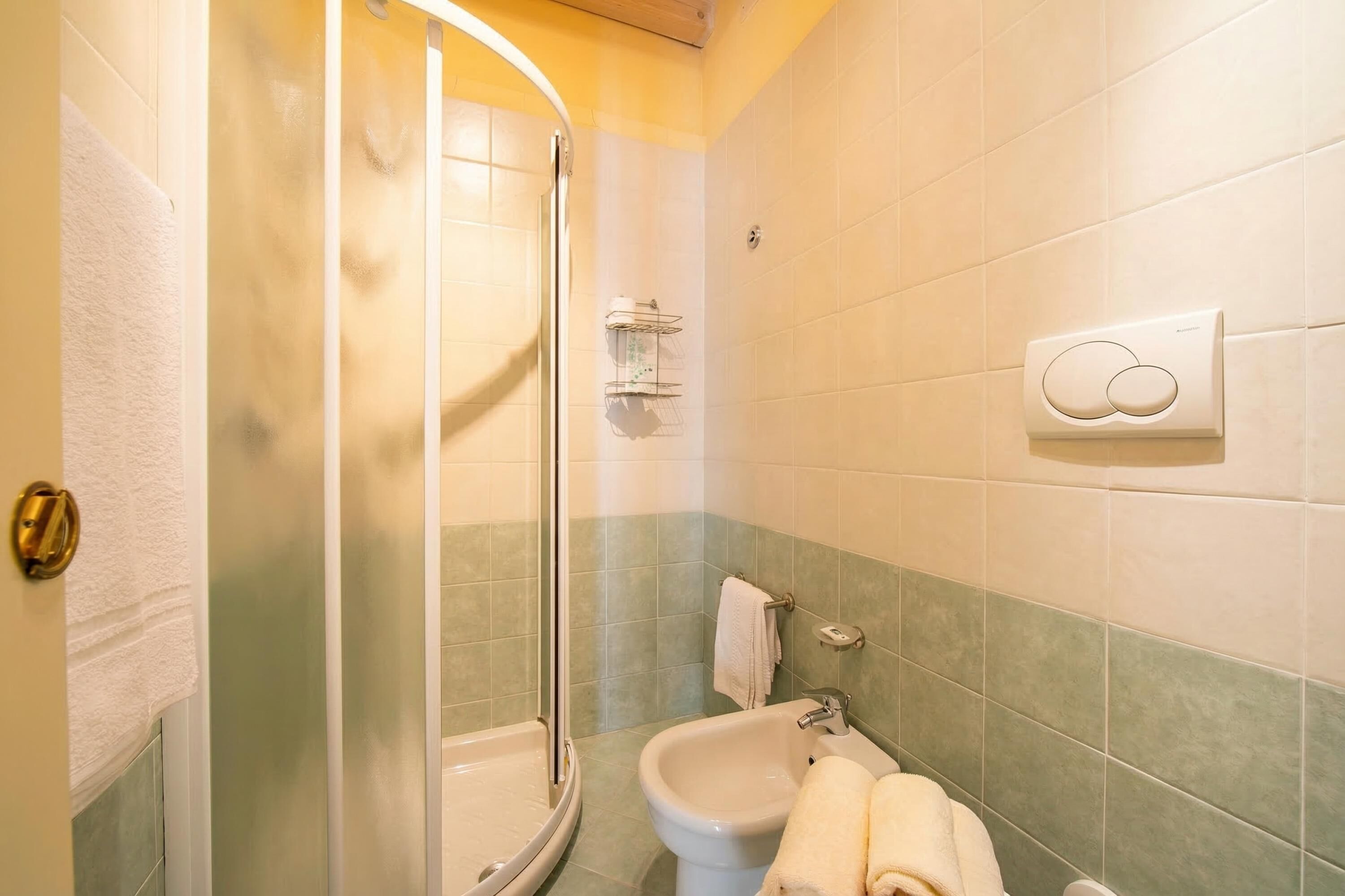 Ein Badezimmer mit einer Duschkabine, einem Waschbecken und einem Handtuchhalter.