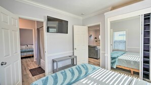 A bedroom with a bed, a bedside table, a TV mounted on the wall, and a door leading to a bathroom. - Pet-Friendly Sacramento Home ~ 5 to Downtown! (Sacramento)