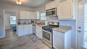 A modern kitchen with white cabinetry, stainless steel appliances, and a granite countertop. - Pet-Friendly Sacramento Home ~ 5 to Downtown! (Sacramento)