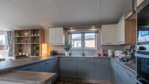 Una cocina moderna con armarios grises, encimera de madera y un suelo con patrón de espiga.