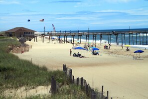 Guests can enjoy a stroll along the pier, taking in the ocean views and relaxing under the shade of beach umbrellas.
