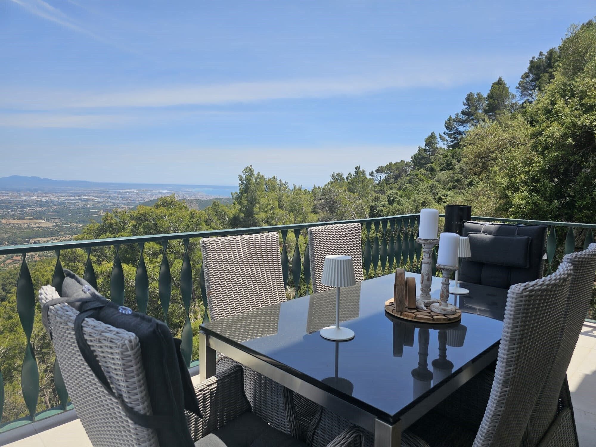 Un balcón con mesa y sillas, con vistas a un paisaje pintoresco.