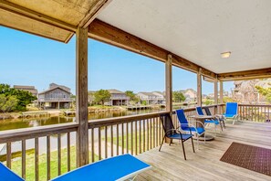 Relax on the deck overlooking the water with comfortable seating and a small table.