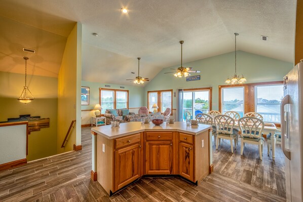 Enjoy meals in the kitchen with a large island and dining area near large windows offering a view of the outdoors.