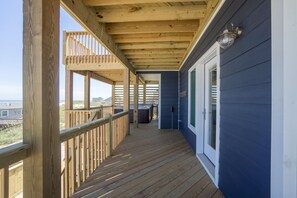 Enjoy the serene view from this outdoor deck with a glass door leading to an interior space.