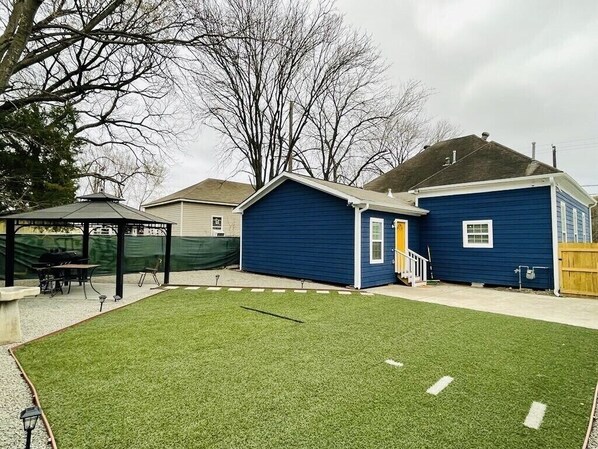 Enjoy the serene atmosphere of this beautifully maintained backyard with a gazebo and a wooden deck.