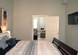 Relax in this stylish bedroom with a large bed and mounted TV.