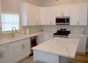 Enjoy cooking in this well-equipped kitchen with a central island, dishwasher, and stainless steel appliances.