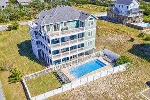 Enjoy the serene surroundings and expansive views from the balcony of this multi-story residence, featuring a large pool and beautifully landscaped grounds.
