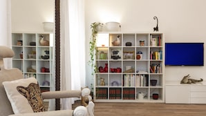 Een woonkamer met een bank, een boekenkast en een televisie.