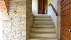 A staircase with stone walls and a wooden door. - MULINO DELLA RASSINA - MULINO DELLA RASSINA (Arezzo)