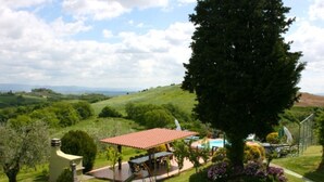 Una propiedad residencial con piscina, terraza cubierta y parque infantil.