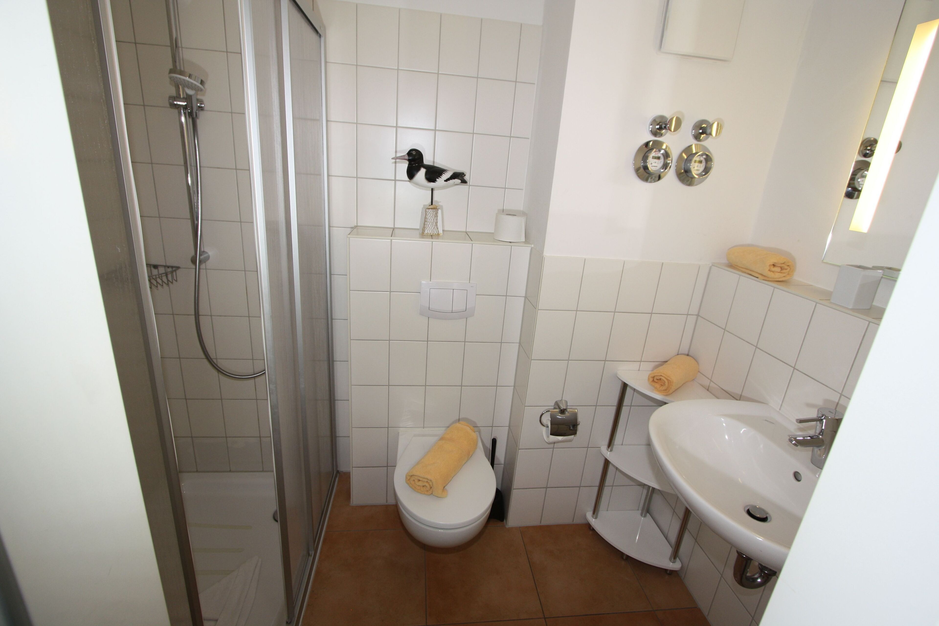 Une salle de bain équipée d’une douche, de toilettes, d’un lavabo et d’un porte-serviettes.