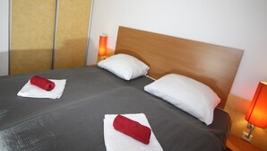 Ein Hotelzimmer mit einem großen Bett, zwei Kissen und zwei Nachttischlampen.