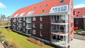 A multi-story residential building with brick exterior, red-tiled roof, and balconies. - HLI 1.11 up to 6 people 69sqm - Residenz Hohe Lith Cuxhaven (1.1) (Cuxhaven)