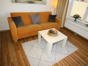 Un salon avec un canapé, une table basse et une fenêtre donnant sur un beau paysage.