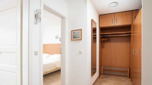 Una habitación de hotel con una cama, un armario y un pequeño cuadro en la pared.