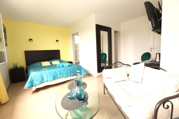 A bedroom with a bed, a bedside table, a chair, and a mirror. - Carpe Diem Tolosa (Vieille-Toulouse)
