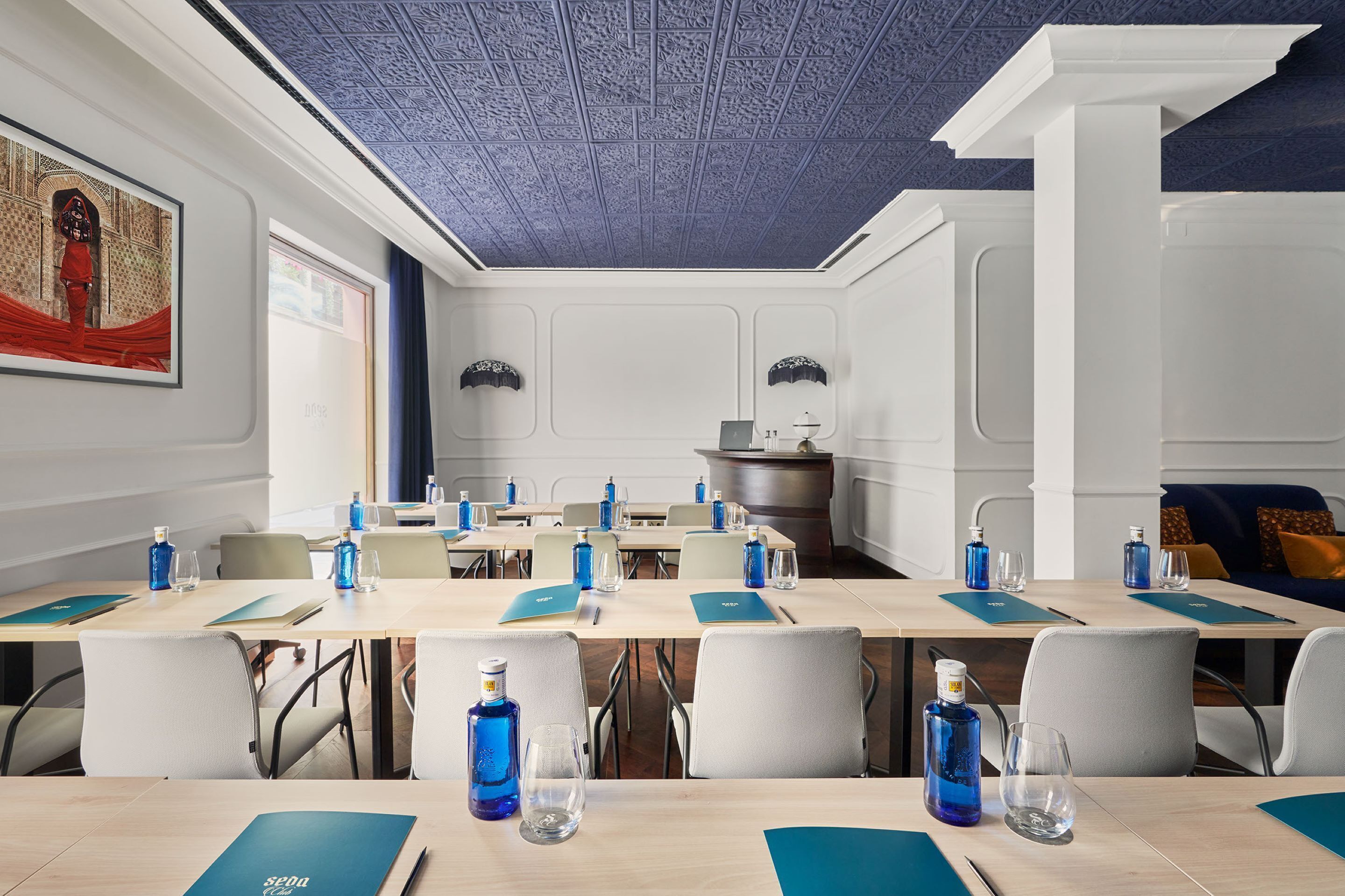 A conference room with tables, chairs, and water bottles.