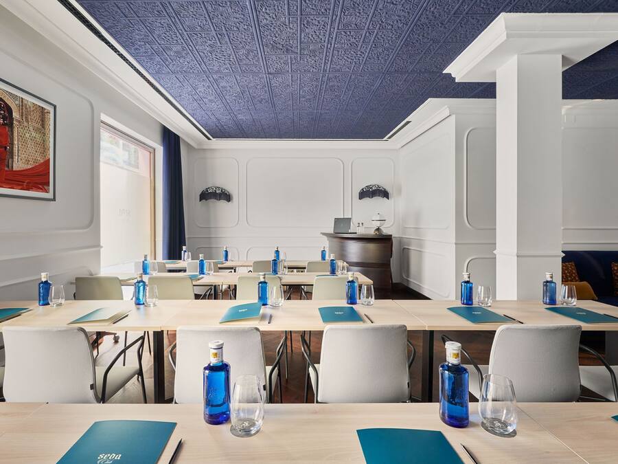 A conference room with tables, chairs, and water bottles.