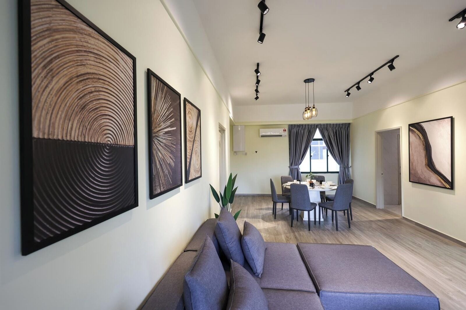 Un interior moderno con comedor, sofá y obras de arte en las paredes.